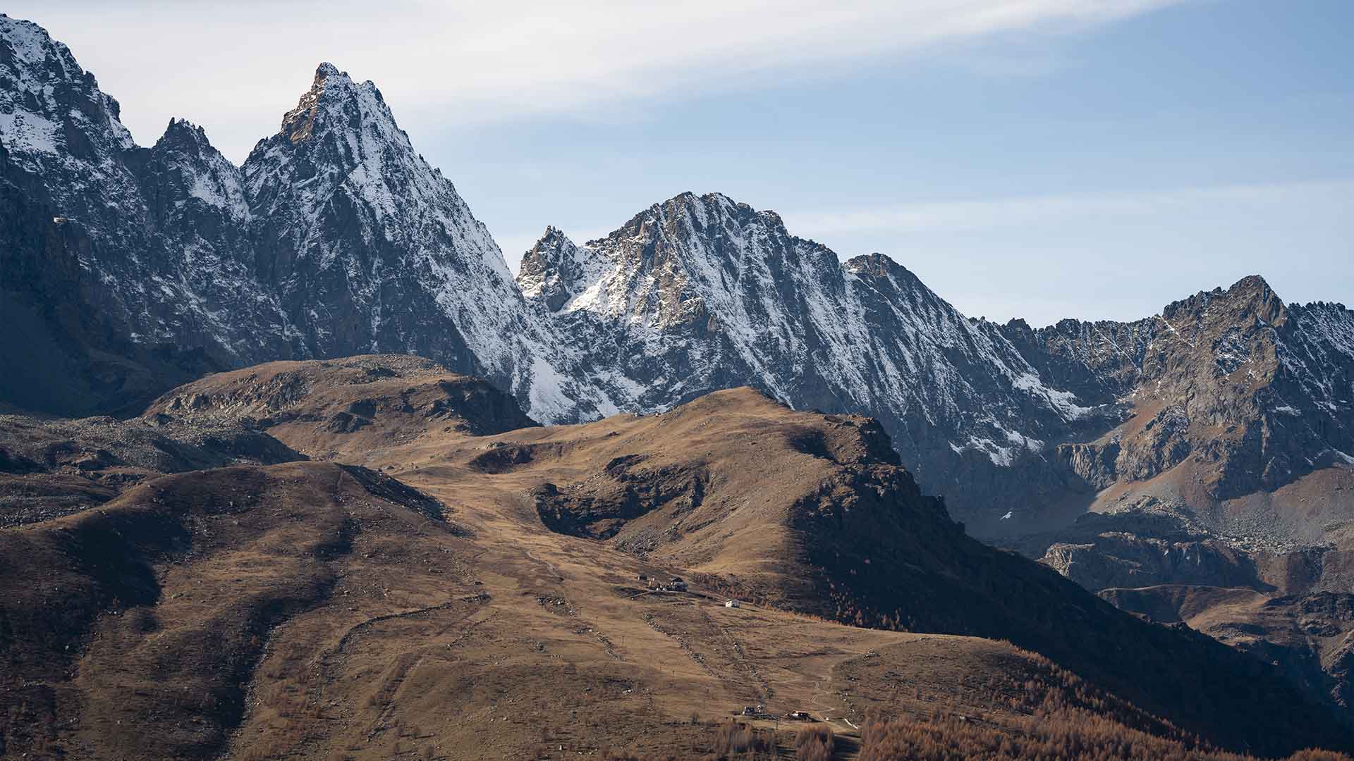 Cime alpine innevate e pascoli d'alta quota sopra Ostana in Valle Po